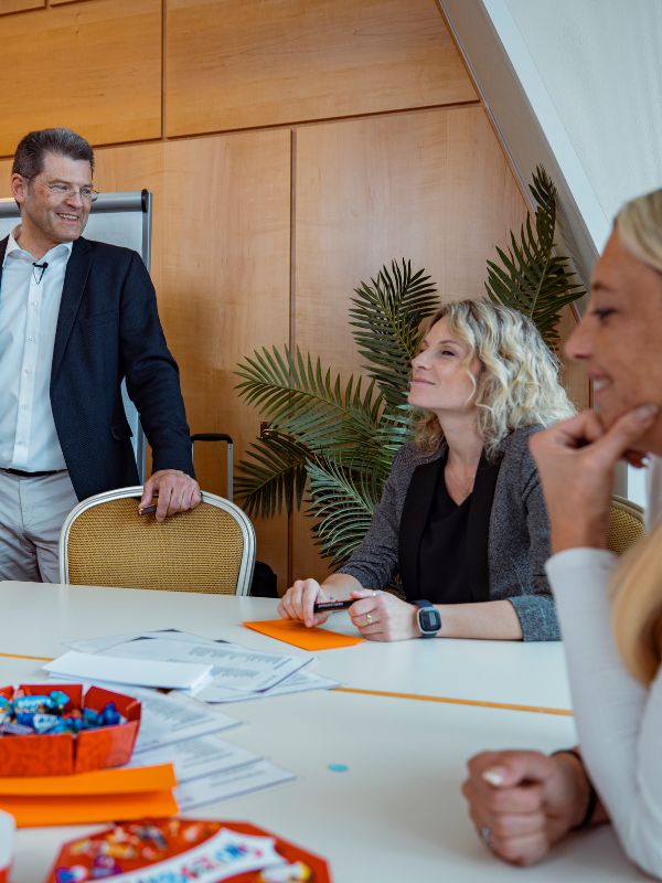 Managementteam diskutiert Szenariomanagement zur strategischen Organisationsänderung und strukturierten Entscheidungsfindung im Unternehmen.