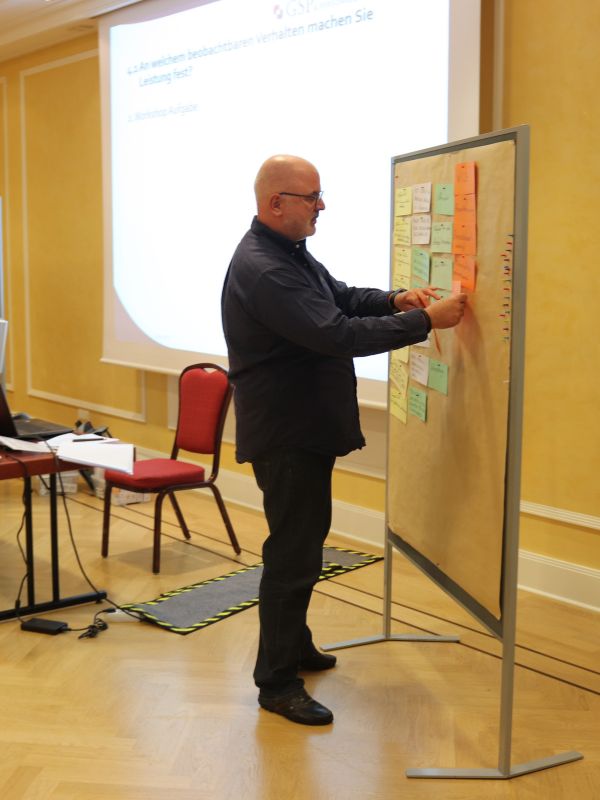 Referent visualisiert Szenariomanagement zur Restrukturierung und strategischen Organisationsveränderung mit Moderationswand und Prozessanalyse in einem Workshop.
